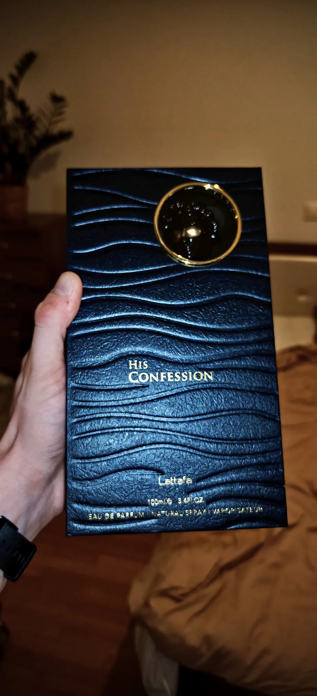 The wave-embossed outer box, gold foil reading His Confession, Eau de Parfum, 100 ml