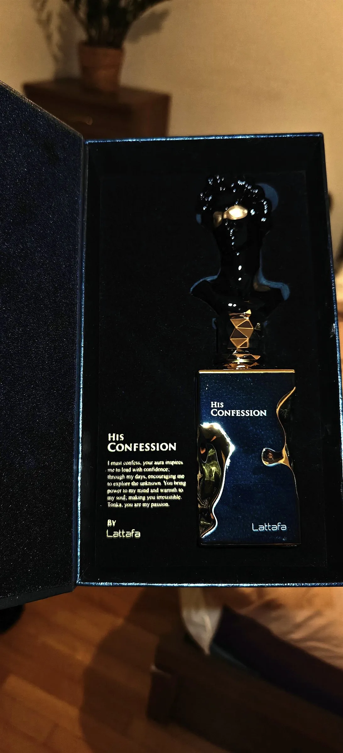 The presentation box open to reveal midnight-navy velvet and a gold poem panel