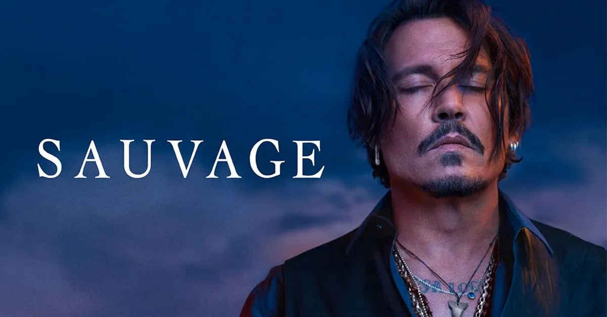 Johnny Depp at blue hour, eyes closed against a bruised twilight sky, the SAUVAGE wordmark floating in white serif capitals across the deepening blue